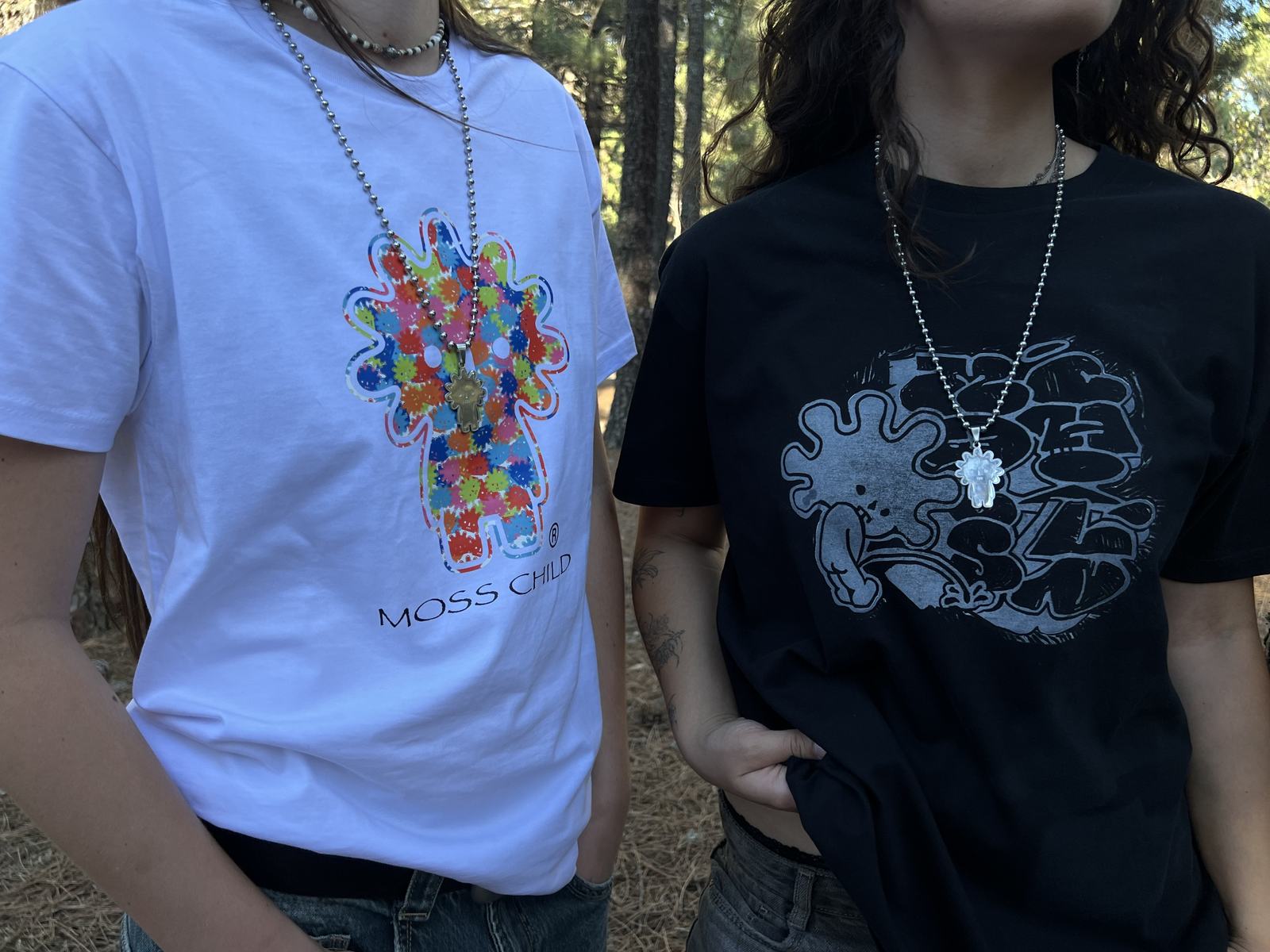 Dos personas con camisetas y cadenas MOSSCHAIN en un pinar